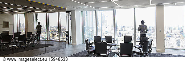 Geschäftsmann steht am Fenster eines modernen Konferenzraums