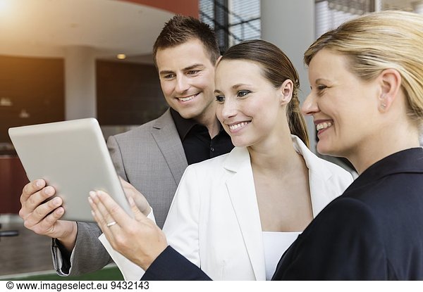Geschäftsmann und Geschäftsfrau tauschen Informationen auf digitalen Tabletts aus