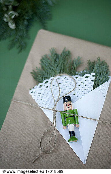 Geschenkpapier verziert mit Tannenzweigen  Deckchen und kleiner Nussknacker-Figur