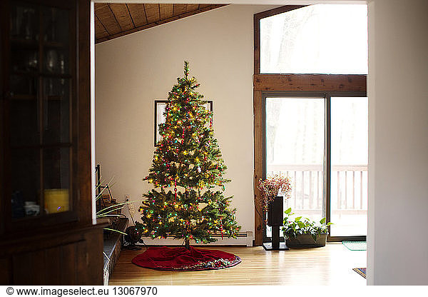 Geschmückter Weihnachtsbaum am Fenster zu Hause
