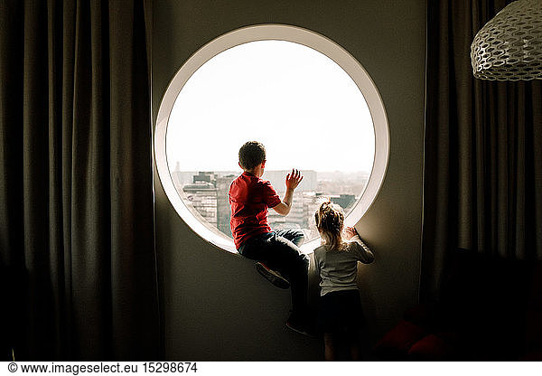 Geschwister am Fenster im Hotelzimmer