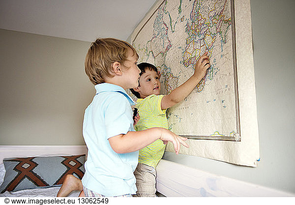 Geschwister betrachten Karte an der Wand