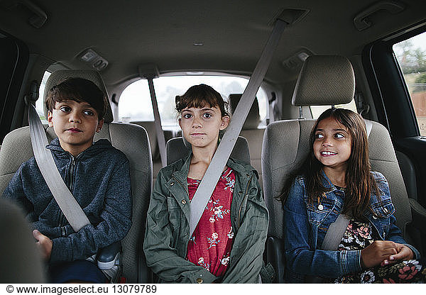 Geschwister sitzen nebeneinander im Auto