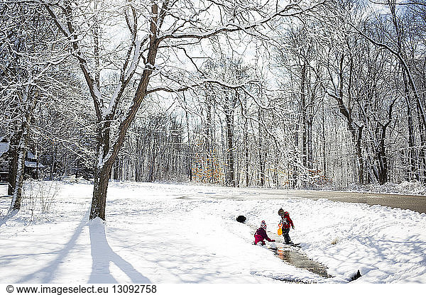 Geschwister spielen auf schneebedecktem Feld