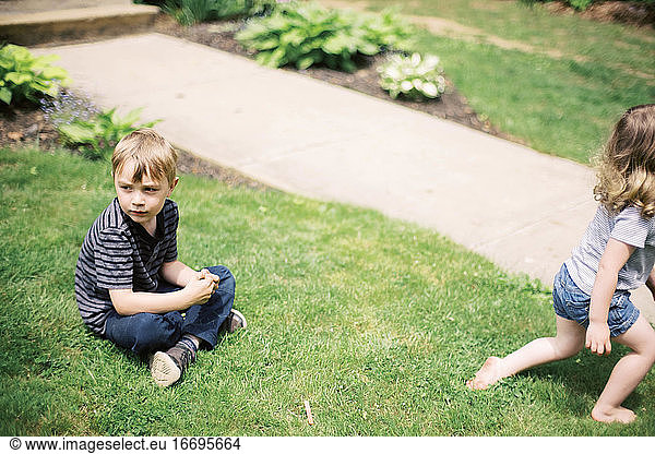 Geschwister spielen im Garten