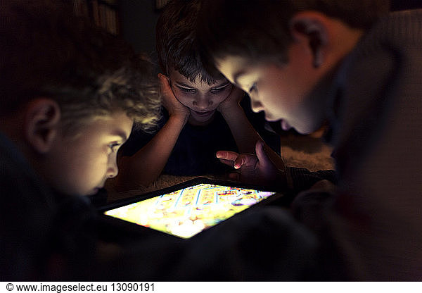 Geschwister spielen zu Hause ein Spiel auf einem Tablet-Computer