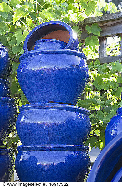 Gestapelte bemalte blaue Töpfe im Gartencenter.