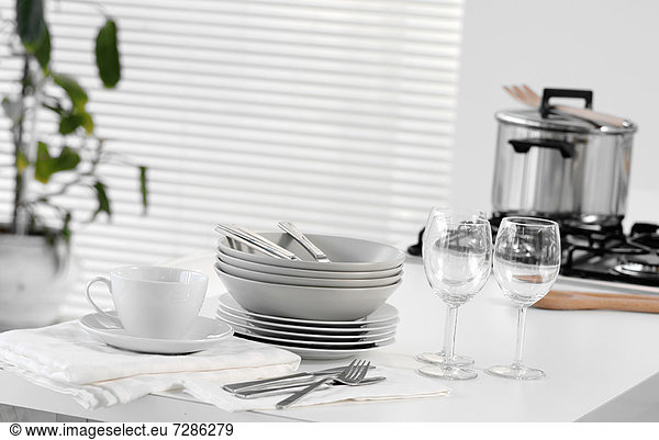 Gestapeltes Geschirr und Besteck auf dem Tisch
