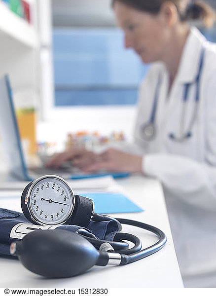 Gesundheitscheck  Arzt untersucht Patientenakten nach einer Konsultation mit Schwerpunkt auf einem Blutdruckmessgerät