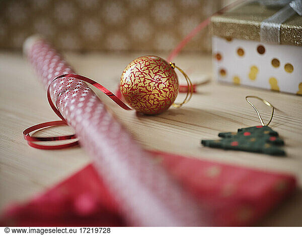Gift wrapping paper with ribbon and Christmas decoration on table