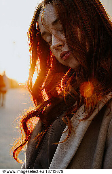 Ginger Girl with Freckles at Sunset near Old Architecture
