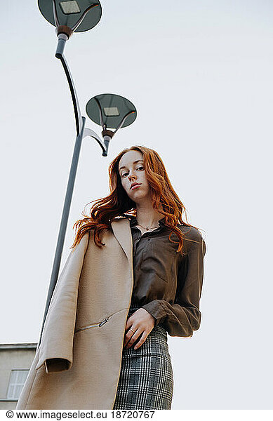 Ginger Girl with Freckles at Sunset near Old Architecture