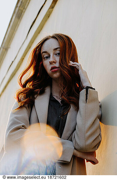 Ginger Girl with Freckles at Sunset near Old Architecture