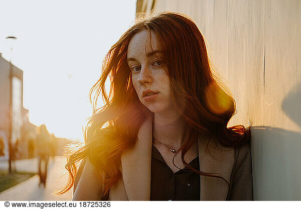 Ginger Girl with Freckles at Sunset near Old Architecture