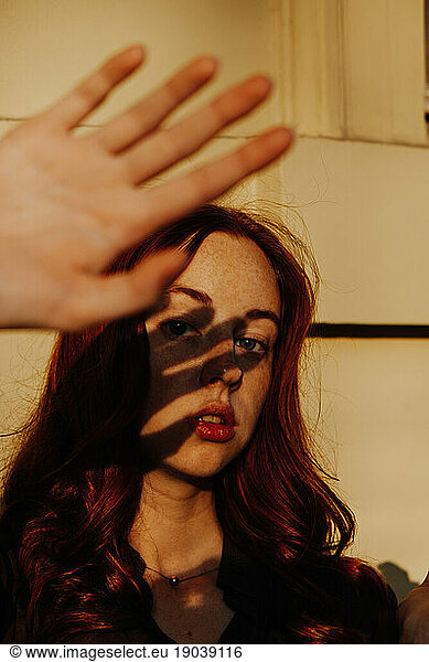 Ginger Girl with Freckles at Sunset Rising Hand to Hide From Sun