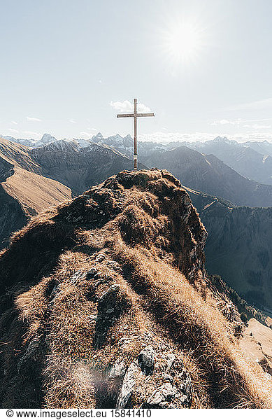 Gipfel mit Kreuz in deutschen Alpen gegen blauen Himmel