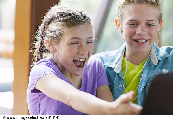 Girl and boy using computer  laughing