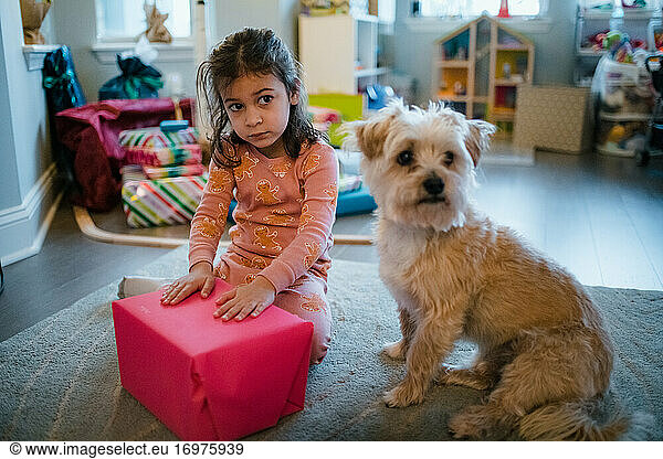 Girl and dog waiting to open presents on Christmas morning
