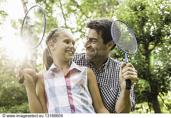 Girl and male relation holding badminton rackets