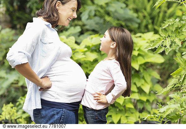 Girl bumping pregnant mother’s belly
