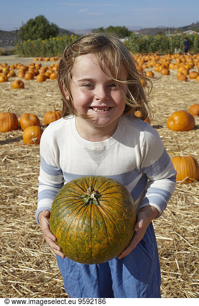 Girl carrying pumpkin