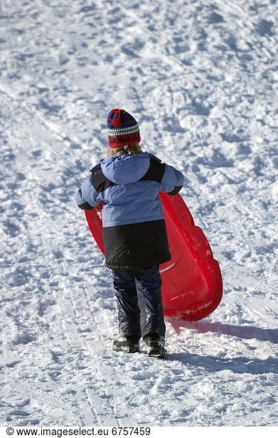 Girl Carrying Sled back up Hill