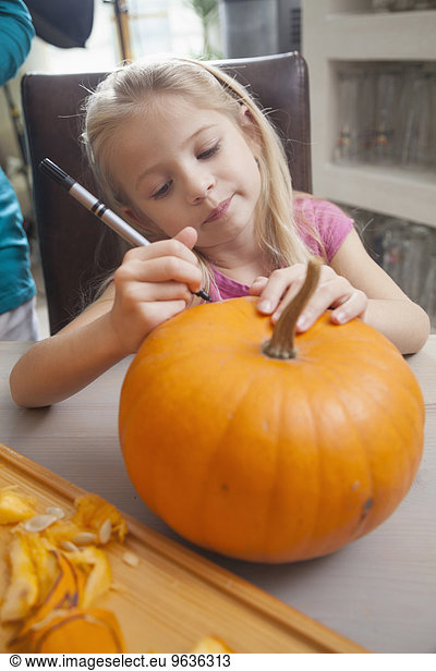 Girl carving pumpkin for Halloween