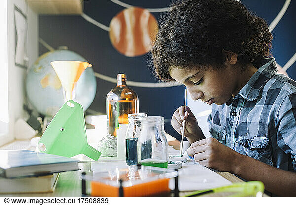 Girl concentrating while doing science project at home