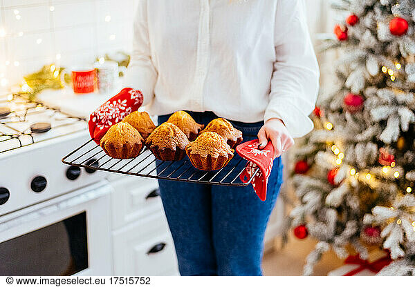 Girl cooks Christmas cupcakes in the kitchen