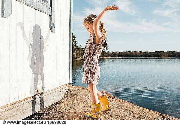 girl dancing using her imagination playing dress up at the beach