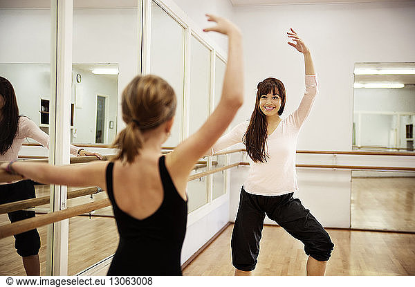 Girl dancing with teacher in dance studio