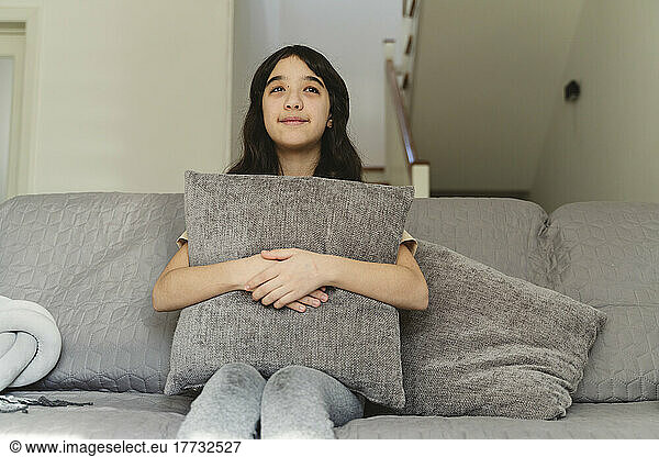 Girl day dreaming sitting on sofa