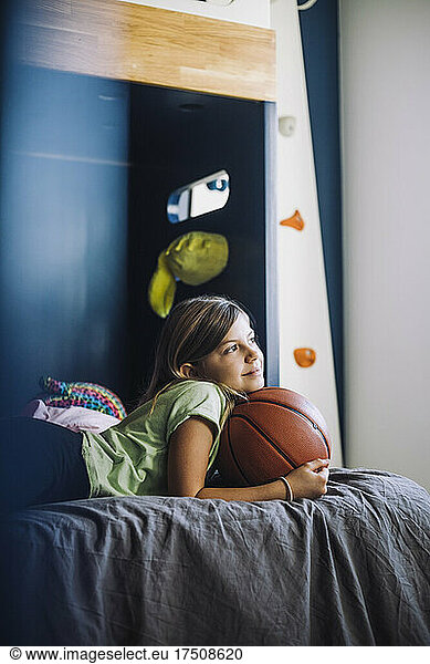 Girl day dreaming while lying down on bed at home