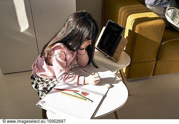 Girl doing homework in the living room