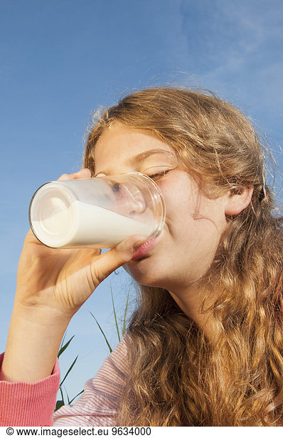 Girl (12-13) drinking glass of milk outdoors  eyes closed  portrait  close-up