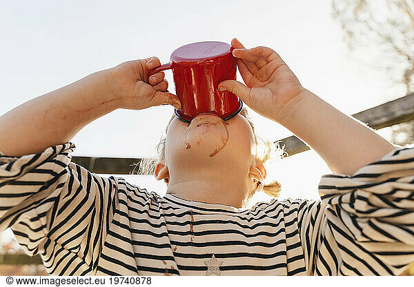Girl drinking hot chocolate on sunny day