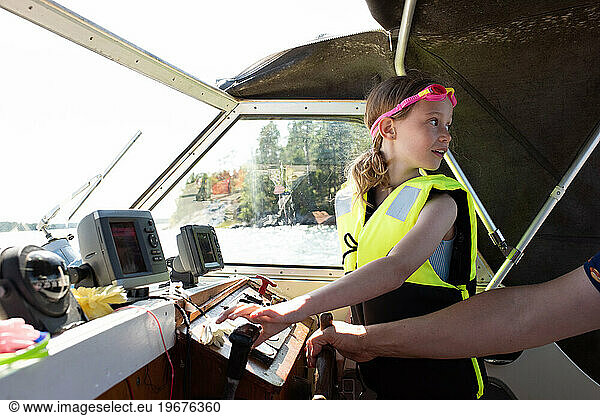 girl driving a motorboat with help at sea