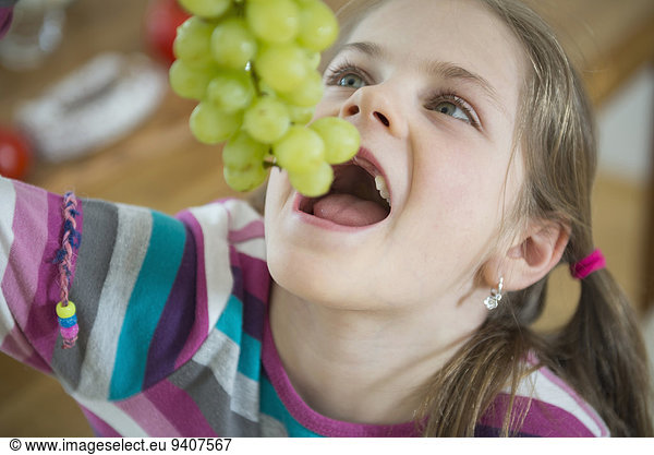 Girl eating bunch of grapes  close up