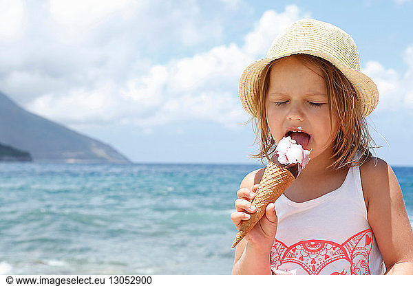 Girl eating ice cream cone on beach  Scopello  Sicily  Italy
