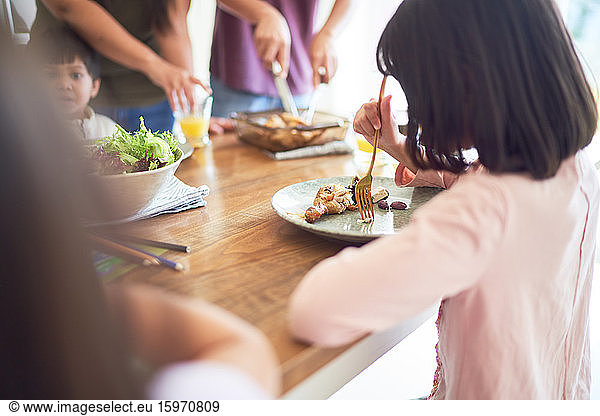 Girl eating lunch at dining table