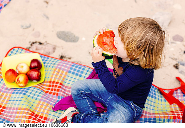 Girl eating watermelon at beach