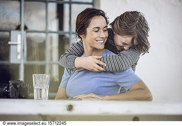 Girl embracing mother  sitting at home
