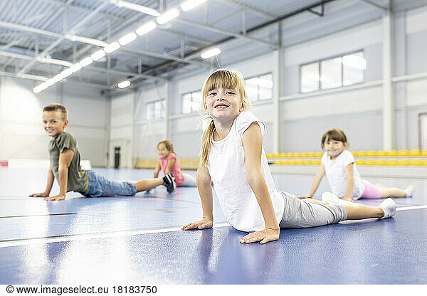 Girl exercising with elementary students at school sports court