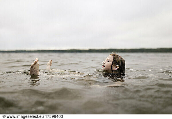 Girl floating in lake water