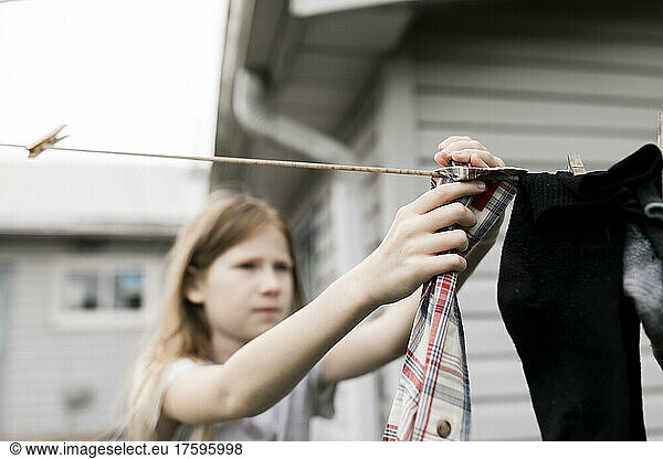 Girl hanging clothes on rope