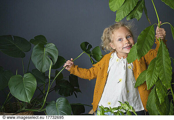 Girl having fun with houseplants at home