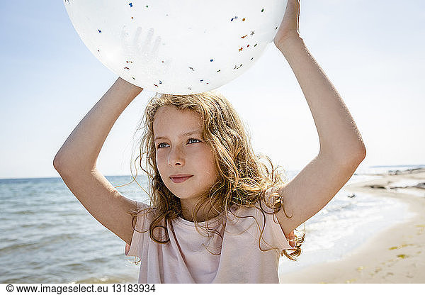 Girl holding a balloon at the beach
