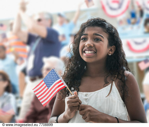 Girl holding american flag  looking anxious