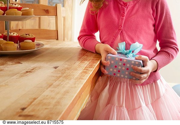Girl holding birthday present  mid section
