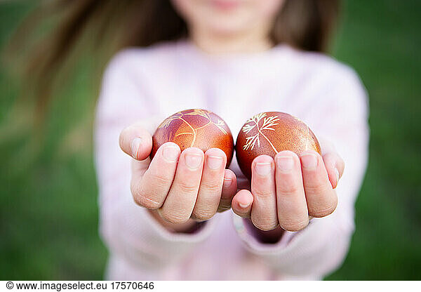 Girl holding Easter Eggs on a green background. Natural concept